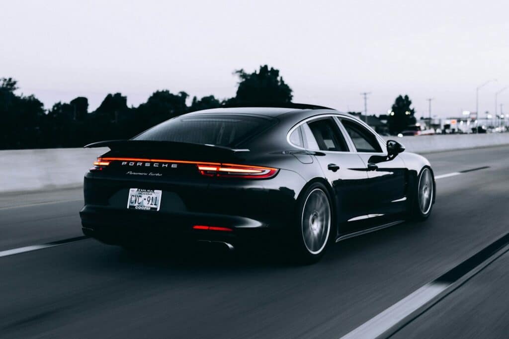 Dark Porsche sedan on the highway — vinyl wrap finish photo